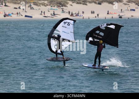 Cabedelo, Viana do Castelo, Portogallo - 21 agosto 2025: Varietà di attività di surf sulla spiaggia dell'Oceano Atlantico, kitesurf, windsurf Foto Stock