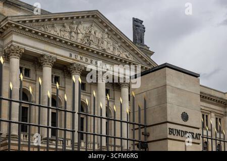 Deutscher Bundesrat, Berlin, 23.08.2025 Blick auf das klassizistische Gebäude des Bundesrates in Berlin mit seinem markanten Säulenportal und dem Schriftzug BUNDESRAT am Giebel. Im Vordergrund ein schmiedeeisernes Tor mit vergoldeten Spitzen und moderner Säule mit Bundesadler und Beschriftung. Berlin Berlin-Mitte Berlin Deutschland *** Consiglio federale tedesco, Berlino, 23 08 2025 Vista dell'edificio neoclassico del Consiglio federale di Berlino con il suo suggestivo portale colonnato e la scritta BUNDESRAT sul timpano in primo piano un cancello in ferro battuto con punte dorate e colonna moderna W Foto Stock