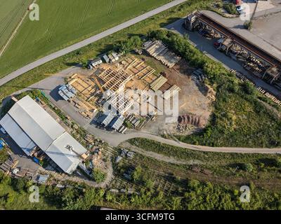 Società di costruzioni che costruiscono case in legno con gru catturate dalla vista aerea Foto Stock