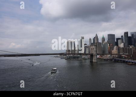 Manhattan, New York. Presa il 15 luglio 2025. Lower Manhattan Skyline in una nuvolosa giornata estiva con vista sul fiume est e sul ponte di Brooklyn. Foto Stock