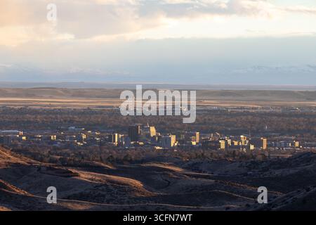 Una città è visibile in lontananza con una catena montuosa nel bosco Foto Stock