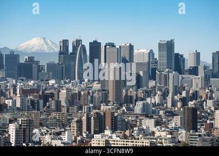 La vista dei grattacieli di Shinjuku e del centro di Tokyo con la cima innevata del Monte Fuji in lontananza. Foto Stock