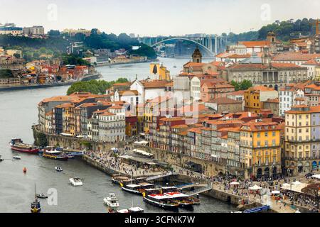 Piazza Ribeira e il lungomare di Cais da Ribeira, sul fiume Douro a Porto, Portogallo, con il ponte da Arrábida sullo sfondo Foto Stock