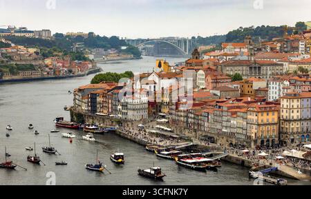 Piazza Ribeira e il lungomare di Cais da Ribeira, sul fiume Douro a Porto, Portogallo, con il ponte da Arrábida sullo sfondo Foto Stock