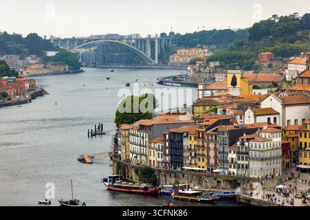 Piazza Ribeira e il lungomare di Cais da Ribeira, sul fiume Douro a Porto, Portogallo, con il ponte da Arrábida sullo sfondo Foto Stock