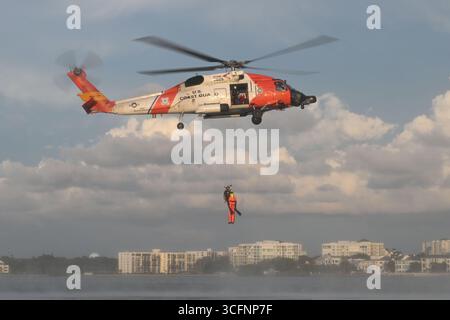 Un equipaggio della U.S. Coast Guard Air Station Clearwater MH-60 Jayhawk vola attraverso il cielo durante l'addestramento a Sand Key, Florida, 13 agosto 2025. Costa degli Stati Uniti Foto Stock