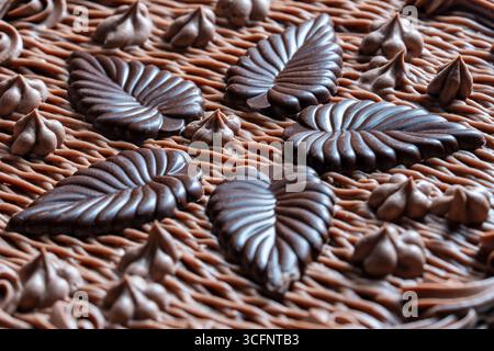 Superficie torta al cioccolato con glassa e caramello decorata con foglie di cioccolato, primo piano Foto Stock