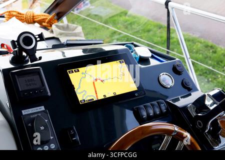 Vista del pannello di governo dell'imbarcazione a motore con volante e schermata di navigazione Foto Stock