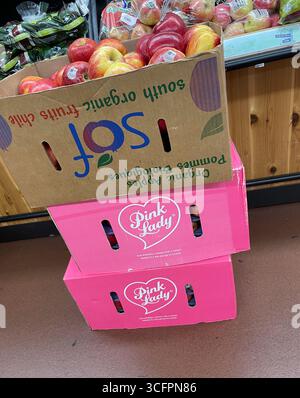 Le scatole rosa di mele sono colorate in un vivace rosa e impilate nella corsia dei prodotti di un supermercato, 2025, Stati Uniti Foto Stock