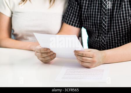 Coppia e lettera per la famiglia o accordo prematrimoniale. Leggere il documento prenup o il divorzio. Liquidazione o debito per la casa. Documento della soluzione. Foto Stock
