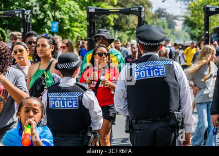 Londra, Regno Unito. 24 agosto 2025. Rilevatori di metalli della polizia durante la discesa dalla stazione di Notting Hill - la domenica del Carnevale di Notting Hill, tradizionalmente giornata dei bambini. L'evento annuale sulle strade del Royal Borough di Kensington e Chelsea, durante il fine settimana delle festività di agosto. È guidata da membri della comunità britannica delle Indie occidentali e attrae circa un milione di persone ogni anno, rendendolo uno dei più grandi festival di strada del mondo. Crediti: Guy Bell/Alamy Live News Foto Stock