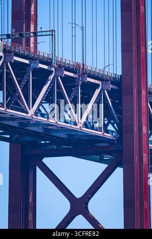 L'immagine mostra una vista ravvicinata di una struttura a ponte rosso contro un cielo blu chiaro. Foto Stock