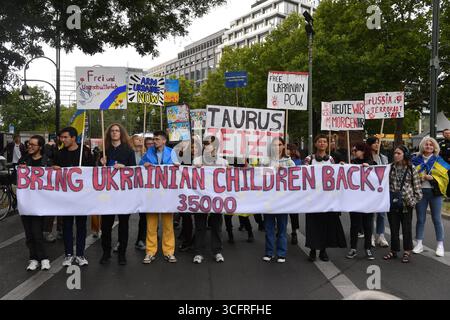 Berlino, Germania. 24 agosto 2025. I cittadini prendono parte alla manifestazione con lo slogan "il futuro ha bisogno di ricordare” per celebrare l'anniversario dell'indipendenza dell'Ucraina il 24 agosto. Uno striscione dice: "Riporta indietro i bambini ucraini! - 35000". Si stima che 2000 persone si siano riunite a Breitscheidplatz. Crediti: Paul Zinken/dpa/Alamy Live News Foto Stock