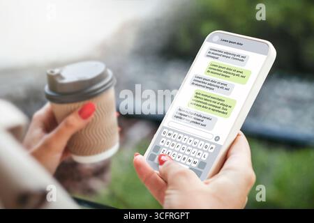 Donna che invia SMS con il telefono all'aperto. Messaggio di testo con smartphone. chat di messaggistica sms. chiacchierare con un amico Foto Stock