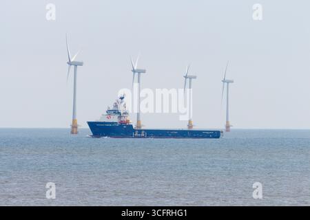 Una nave che passa per turbine eoliche sul Mare del Nord vicino a Caister nel Norfolk Foto Stock