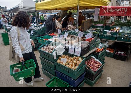 Clienti che acquistano frutta e verdura al mercato domenicale di Stockbridge, Edimburgo, Scozia, Regno Unito. Foto Stock