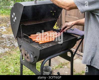 La salsiccia è grigliata in giardino (primo piano) Foto Stock