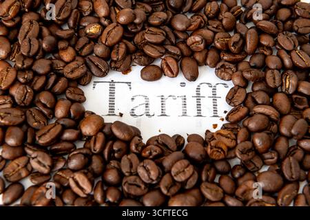 Un mucchio di chicchi di caffè che circondano la parola stampata tariffa. Un concetto di tariffa per il caffè. Foto Stock