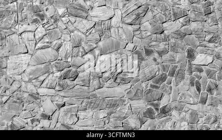 Motivo a parete in pietra grigia a mosaico, vista frontale, texture foto di sfondo senza cuciture, bianco e nero Foto Stock