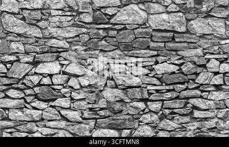 Vecchio muro in pietra grigio scuro, texture fotografica di sfondo senza cuciture, vista frontale, bianco e nero Foto Stock