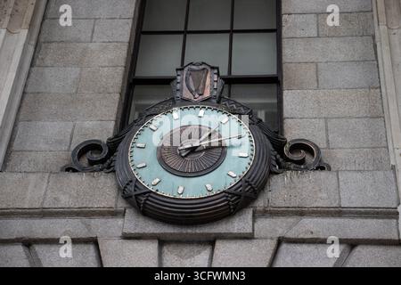Orologio di bronzo al General Post Office di Dublino, Irlanda. Un orologio sull'esterno in pietra del General Post Office di Dublino, Irlanda. Foto Stock