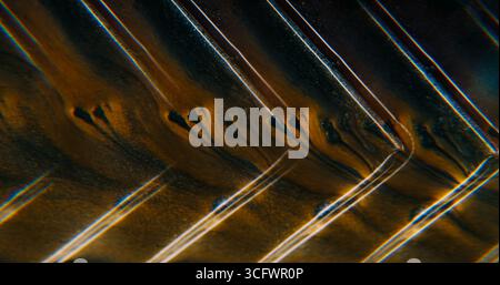 Fuoriuscita di vernice. Angolo geometrico. Le particelle di colore neon giallo sfocato fluiscono nell'acqua pigmento nero scuro che galleggia su sfondo astratto acrilico artistico. Foto Stock