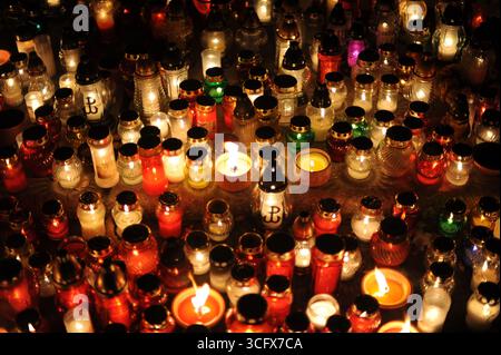 Candele su tombe e lapidi nel cimitero notturno in Polonia nel giorno di Ognissanti o di tutte le anime o Halloween o Zaduszki o il giorno dei morti Foto Stock