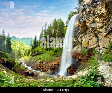 Cascate di Johannes splendidamente lungo le scogliere rocciose di Obertauern. Alberi torreggianti circondano l'area, creando un ambiente sereno perfetto per il n Foto Stock