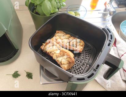 Bruschetta con funghi porcini e formaggio. Cibo e prodotti di qualità cotti nella friggitrice aerodinamica. Cucina tradizionale italiana. Foto Stock