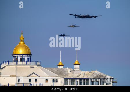 Avro Lancaster e Hawker Hurricanes del RAF Battle of Britain Memorial Flight sorvolando Eastbourne Pier presso Airborne 2025, Eastbourne Foto Stock