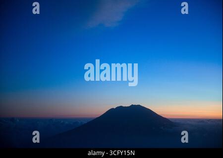 Il picco del Monte Agung visto dalla finestra di un aereo Foto Stock