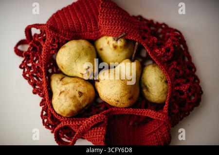 Pere fresche in sacchetto a rete rossa Foto Stock