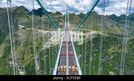 (250825) -- ZHENFENG, 25 agosto 2025 (Xinhua) -- questa foto del drone aereo, scattata il 25 agosto 2025, mostra una prova di carico sul ponte del Grand Canyon di Huajiang nella provincia di Guizhou nella Cina sud-occidentale. Il Huajiang Grand Canyon Bridge, destinato a diventare il ponte più alto del mondo, aveva completato una prova di carico chiave a partire da lunedì, prima della sua apertura prevista a fine settembre. Il processo di test di cinque giorni ha confermato che la resistenza strutturale, la rigidità e le prestazioni dinamiche del ponte rispettavano gli standard di sicurezza, secondo il team di test. La prova di carico, considerata la fase finale prima che il ponte accolga tra Foto Stock