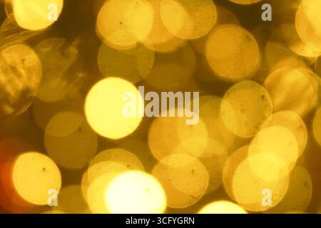Luci bokeh dorate che creano una calda atmosfera festosa per le celebrazioni di Natale e Capodanno. Luci sfocate - sfondo perfetto per le vacanze Foto Stock