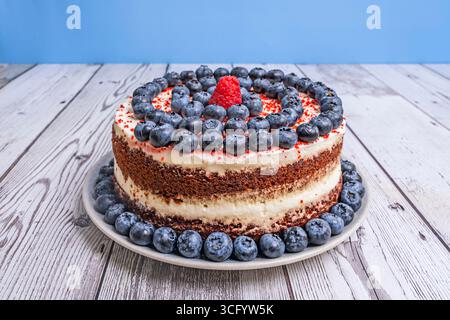 Torta di velluto rosso autunnale: Decorata con mirtilli, fichi freschi e noci pecan caramellati Foto Stock