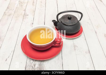 Tè al gelsomino con Lychee: Una bevanda esotica e fragrante con frutta intera al litchi e petali di gelsomino che fluttuano in un elegante bicchiere Foto Stock