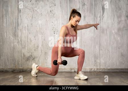 Donna sportiva incinta che fa esercizio in una palestra Foto Stock