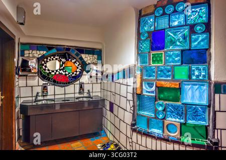 Interno del bagno e della toilette maschile nella "Kunst Haus Wien" creata da Friedensreich Hundertwasser - Vienna, Austria. Foto Stock