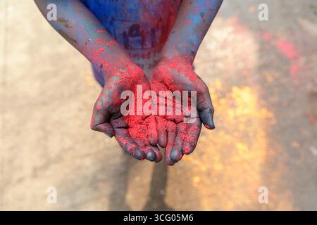 Polvere rossa, colori holi sulle mani dei bambini, celebrazione del festival holi, festival dei colori per le strade di mumbai in india Foto Stock