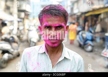 Ritratto di un uomo con colori sul viso, che celebra il festival holi, festival dei colori per le strade del quartiere di mumbai in india Foto Stock