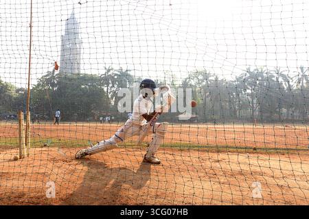Adolescenti che allenano il cricket in una giornata di sole al mattino nel parco Oval Maidan a Bombay, Mumbai, India Foto Stock