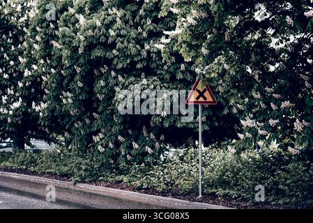 Cartello segnaletico con l'incrocio nero in triangolo giallo in Finlandia Way Road Highway Foto Stock