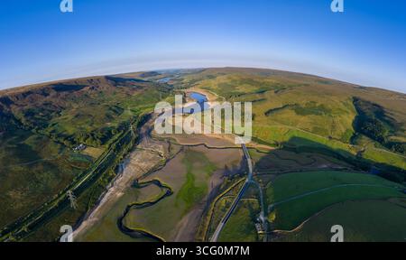 La vista aerea con droni cattura la dura realtà della grave siccità nel lago artificiale Woodhead vicino a Glossop, rivelando vaste distese di terra secca e incrinata. Foto Stock