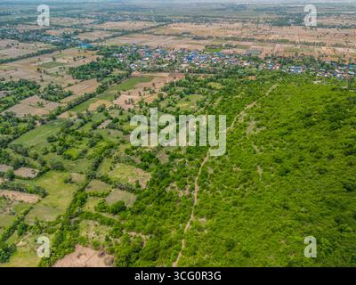 Vista su un villaggio rurale circondato da terreni agricoli e campi verdi vicino a Phnom Chisor nel distretto di Samraŏng, provincia di Takéo, Cambogia. L'agricoltore Foto Stock