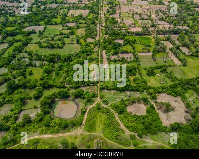 Vista dei droni sui terreni agricoli rurali e sui campi verdi vicino a Phnom Chisor nel distretto di Samraŏng, provincia di Takéo, Cambogia. Il paesaggio agricolo è caratterizzato da Foto Stock