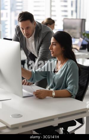 Donna impegnata in una conversazione mirata con un collega maschio Foto Stock