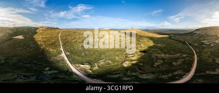 Il paesaggio della tundra si estende attraverso l'orizzonte, Nipfjället Städjan e le sue montagne vicine. La strada sterrata si snoda attraverso la natura selvaggia di Dalarna Foto Stock