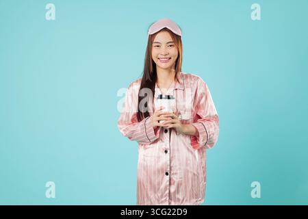 Donna in ritratto di pigiama, sveglia mattutina, sorridente riposo asiatico rilassante a casa Foto Stock