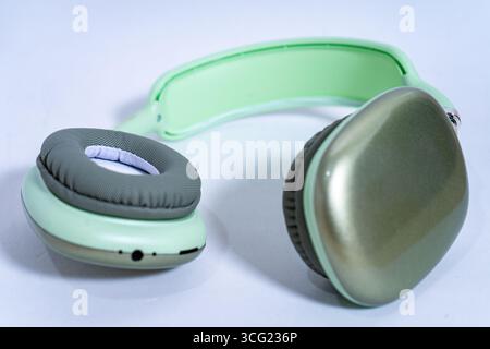 Eleganti cuffie wireless color verde pastello isolate su uno sfondo bianco e pulito, che mettono in risalto la moderna tecnologia audio Foto Stock