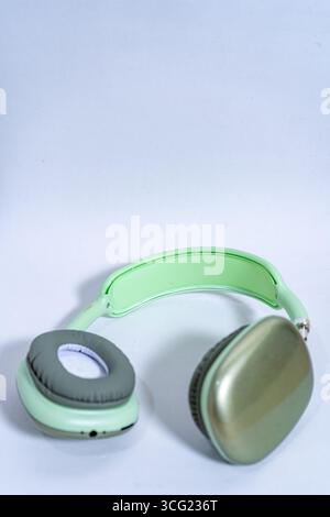 Eleganti cuffie wireless color verde pastello isolate su uno sfondo bianco e pulito, che rappresentano musica, tecnologia e divertimento audio Foto Stock